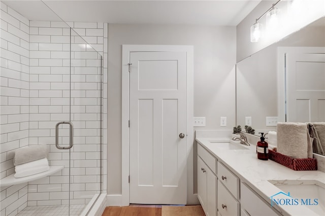 bathroom with vanity, wood-type flooring, and a shower with shower door