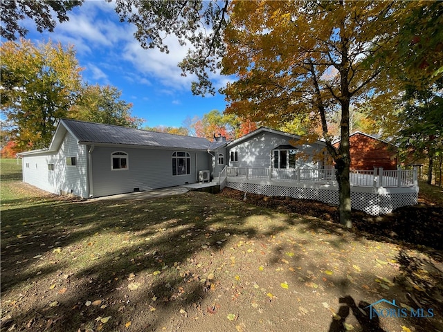 rear view of house with a yard and a wooden deck