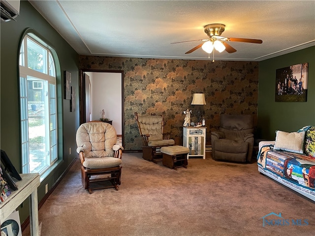 living room featuring ceiling fan, a textured ceiling, carpet flooring, a wall mounted air conditioner, and ornamental molding