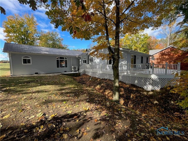 rear view of property featuring a deck and a yard