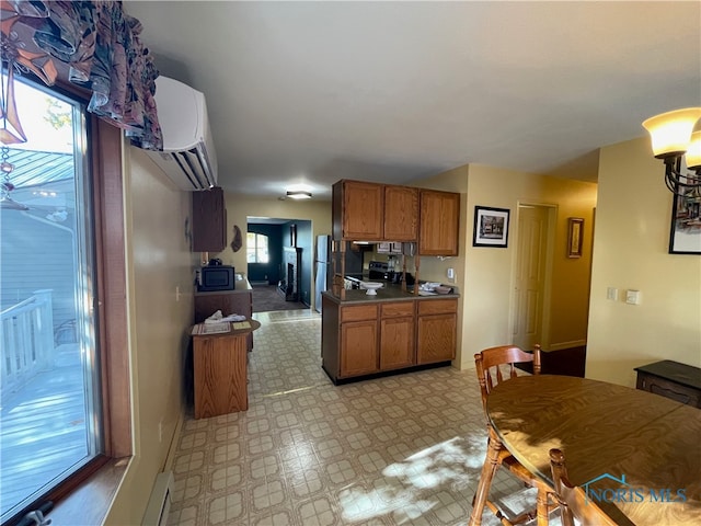 kitchen featuring a wall unit AC, stainless steel appliances, and a baseboard radiator