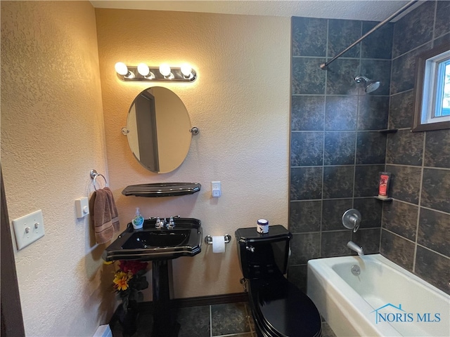 bathroom featuring toilet and tiled shower / bath combo