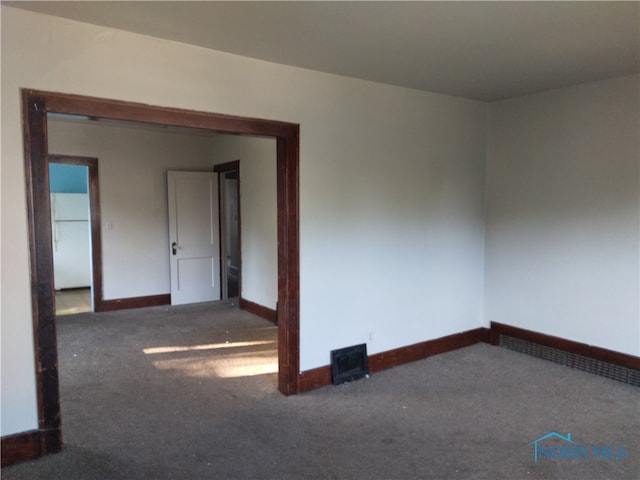 empty room with dark colored carpet