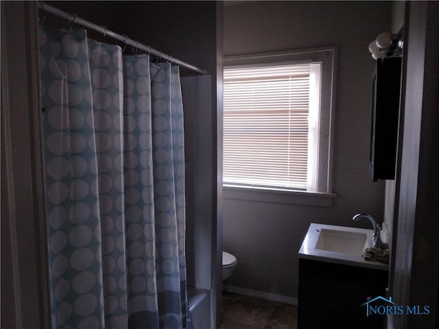 bathroom with a healthy amount of sunlight, vanity, toilet, and walk in shower