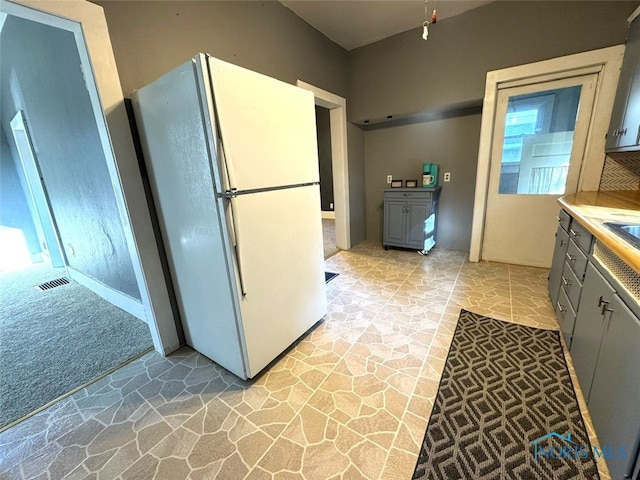 kitchen featuring white fridge and gray cabinetry