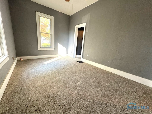 carpeted spare room with ceiling fan