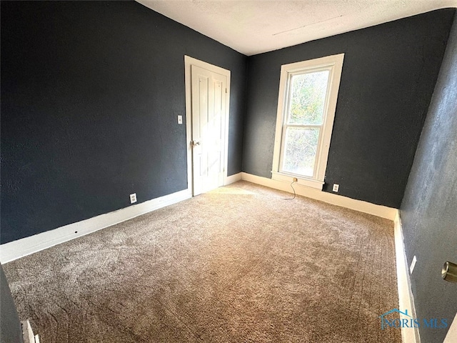 carpeted spare room featuring a textured ceiling