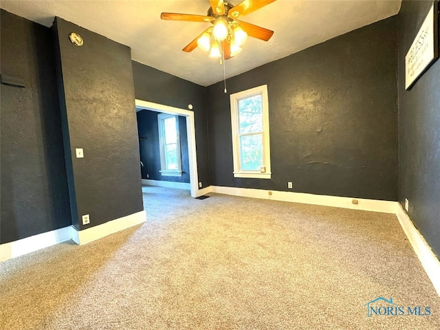 carpeted empty room featuring ceiling fan