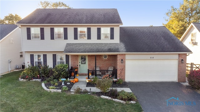 view of front of home featuring covered porch, a front lawn, and a garage