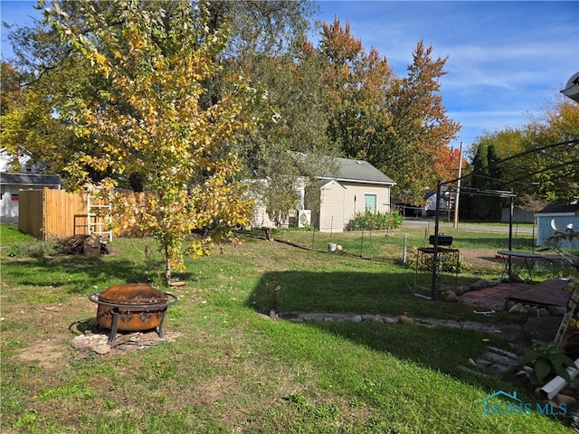 view of yard with a storage unit and a fire pit