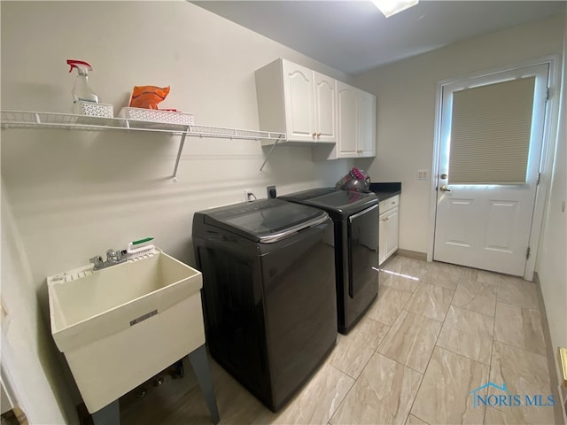 laundry room featuring cabinets, sink, and washer and clothes dryer