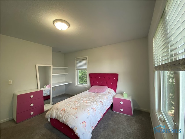 bedroom featuring a textured ceiling and dark colored carpet