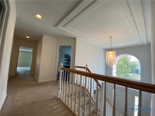 hallway with carpet and an inviting chandelier