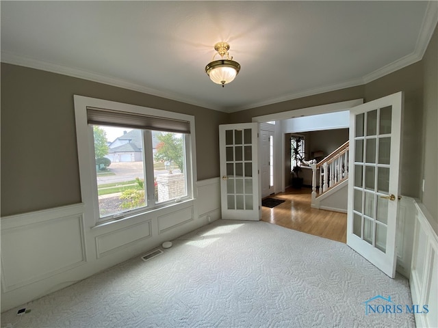 unfurnished room featuring french doors, crown molding, and hardwood / wood-style flooring