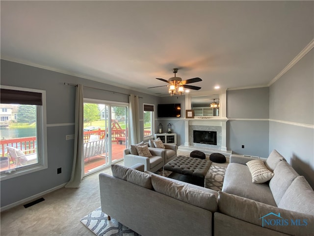 carpeted living room with ornamental molding, a water view, and ceiling fan