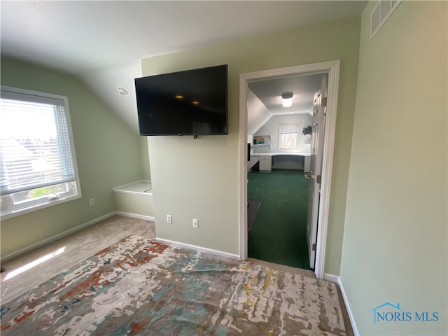 interior space with light carpet and vaulted ceiling