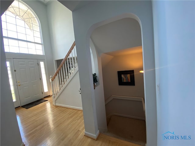 entrance foyer featuring light hardwood / wood-style floors and a towering ceiling