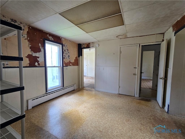 502 N Prospect St, Bowling Green, OH 43402 - empty room featuring baseboard heating, wainscoting, and a paneled ceiling