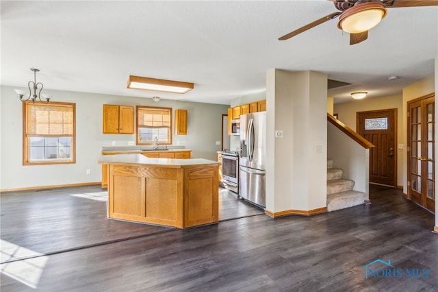 kitchen with appliances with stainless steel finishes, a center island, sink, and dark hardwood / wood-style flooring