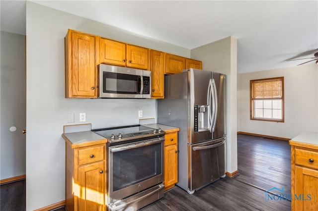 kitchen with ceiling fan, appliances with stainless steel finishes, and dark hardwood / wood-style flooring