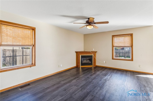 unfurnished living room with dark wood-type flooring and ceiling fan