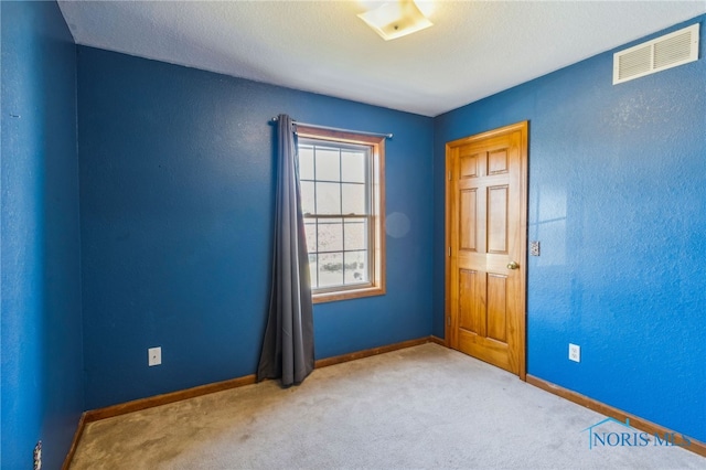 carpeted spare room featuring a textured ceiling