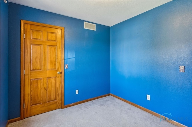 unfurnished room featuring light colored carpet