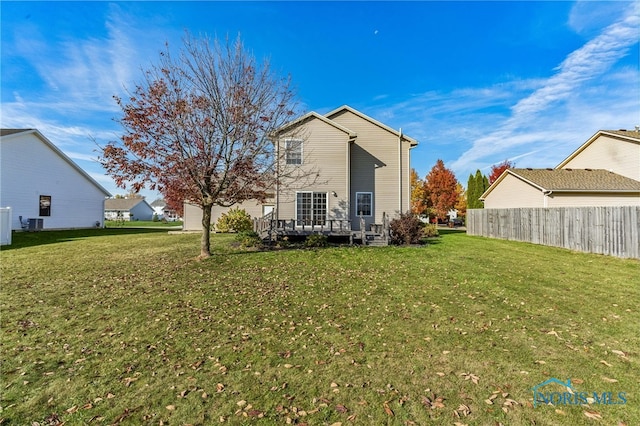 back of property with a wooden deck and a yard