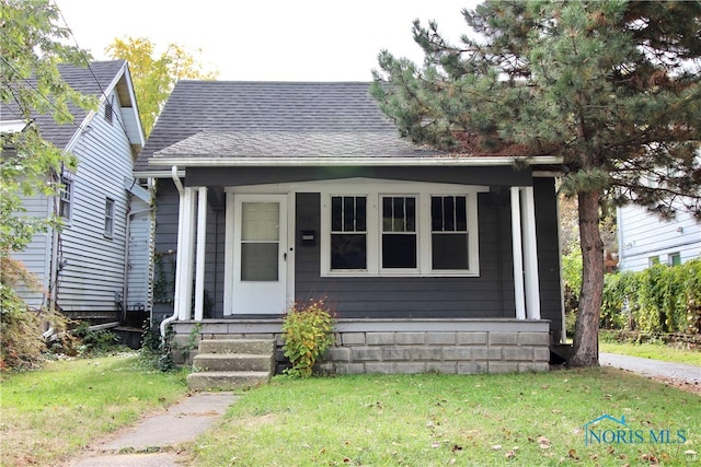 bungalow featuring covered porch and a front lawn