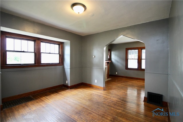 empty room featuring hardwood / wood-style flooring and a healthy amount of sunlight