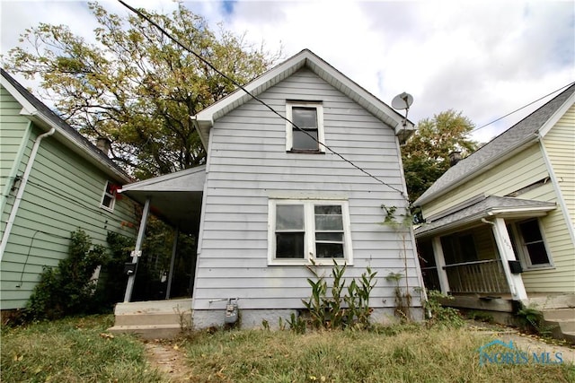 rear view of property featuring covered porch