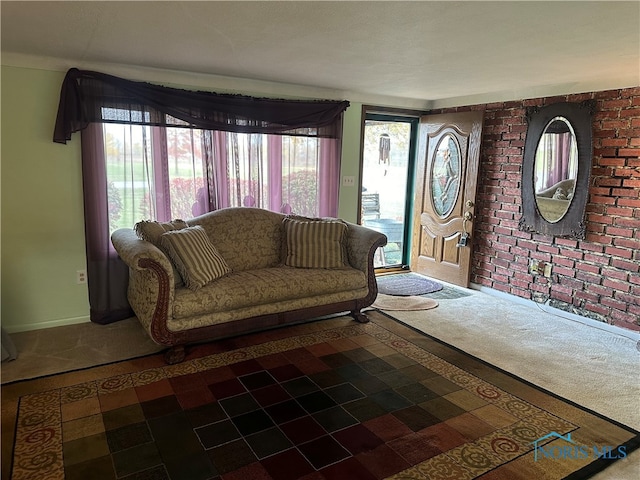 living room with brick wall and carpet flooring