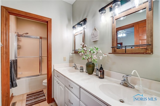 full bathroom with vanity, ceiling fan, enclosed tub / shower combo, tile patterned flooring, and toilet