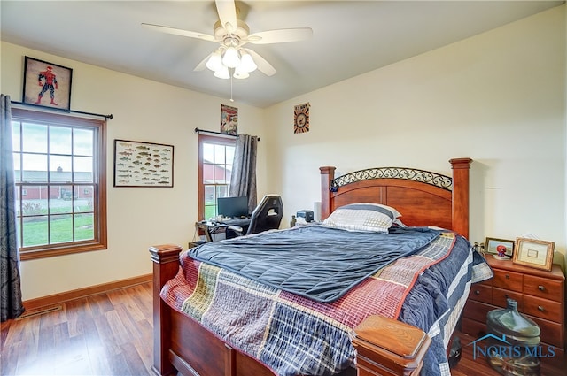 bedroom featuring hardwood / wood-style flooring, ceiling fan, and multiple windows