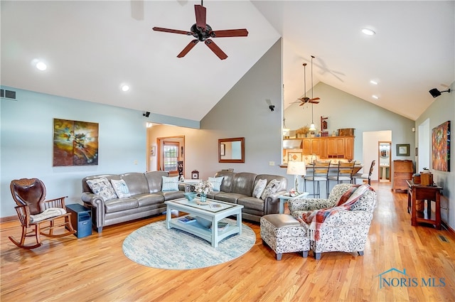 living room featuring ceiling fan, light hardwood / wood-style flooring, and high vaulted ceiling