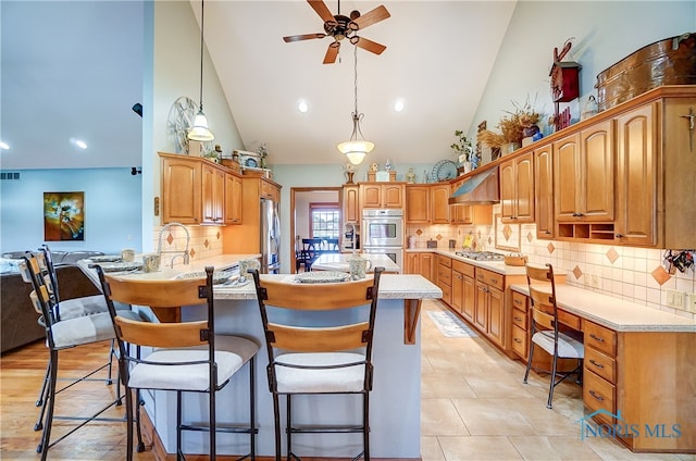 kitchen with pendant lighting, high vaulted ceiling, kitchen peninsula, and appliances with stainless steel finishes