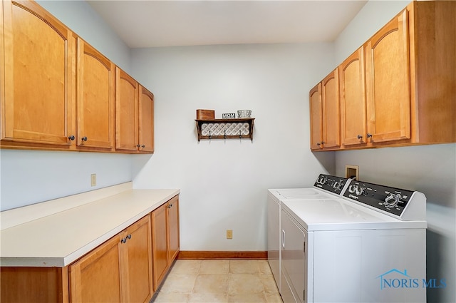 laundry area with cabinets, washing machine and dryer, and light tile patterned flooring