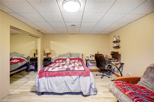 bedroom with hardwood / wood-style flooring and a paneled ceiling