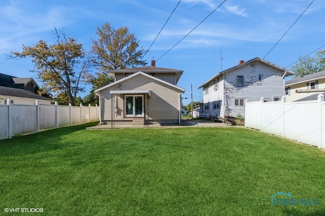 back of property with a patio area and a yard