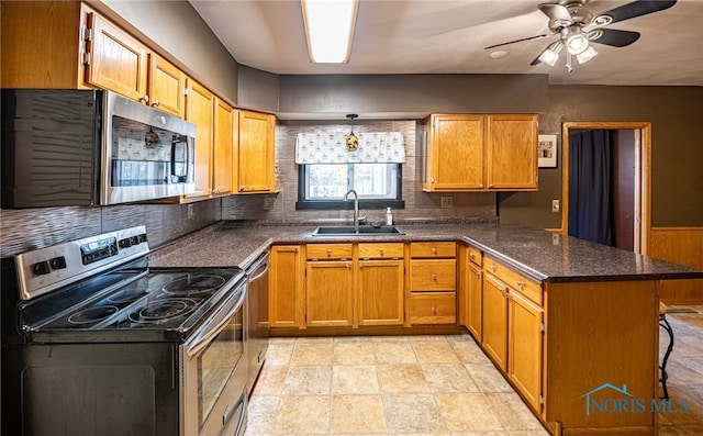 kitchen with appliances with stainless steel finishes, sink, a kitchen bar, kitchen peninsula, and decorative backsplash