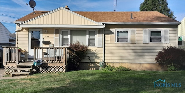 rear view of house with a wooden deck and a yard