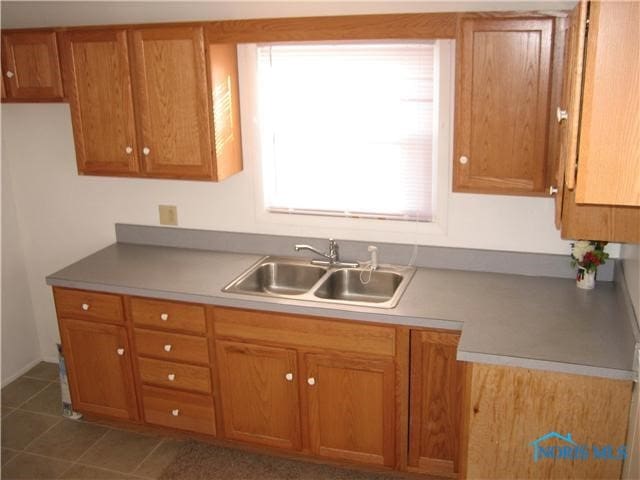 kitchen with sink and dark tile patterned flooring