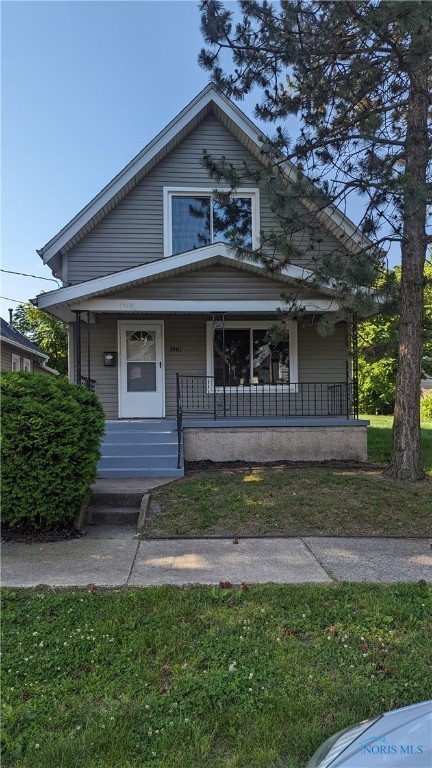 view of front of house featuring covered porch and a front yard