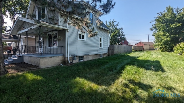 view of property exterior featuring a porch and a lawn