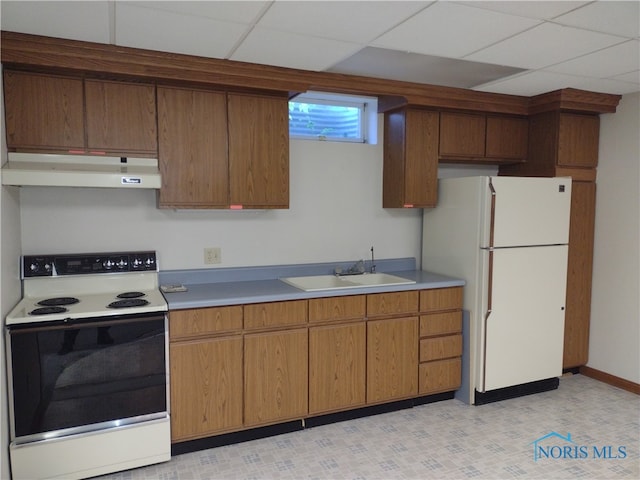 kitchen featuring a paneled ceiling, sink, and white appliances