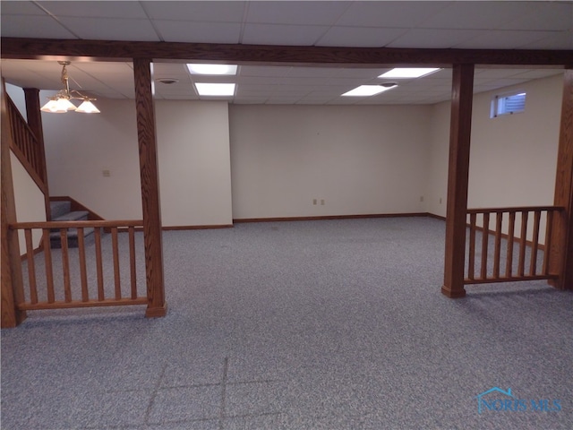 basement featuring a drop ceiling and carpet