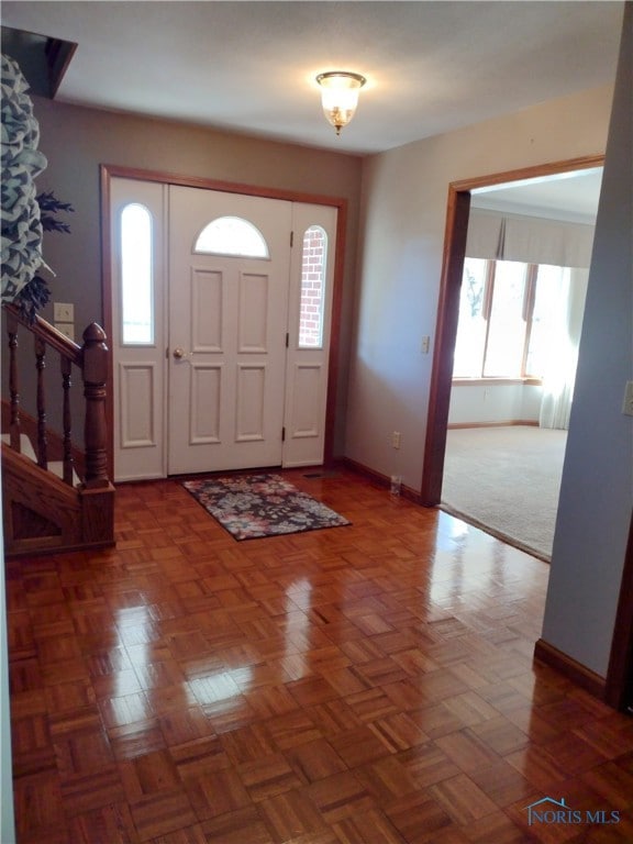 entryway with dark parquet floors