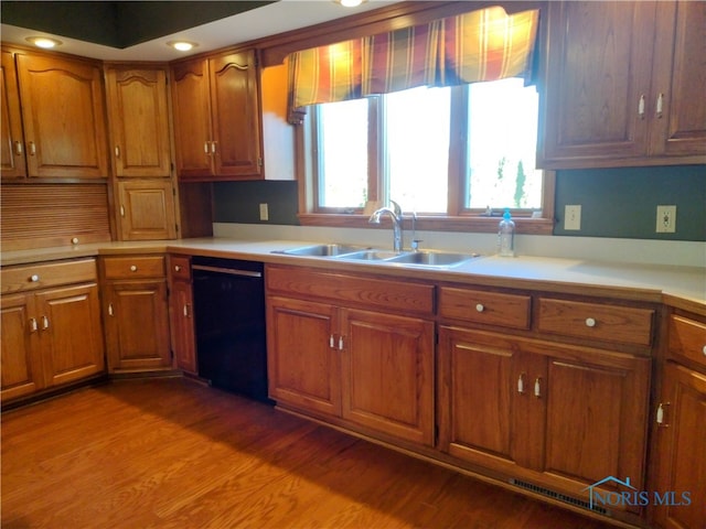 kitchen featuring hardwood / wood-style floors, sink, and dishwasher