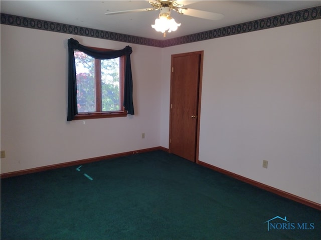 spare room with ceiling fan and dark colored carpet