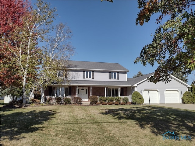 view of front of property with covered porch, a front lawn, and a garage